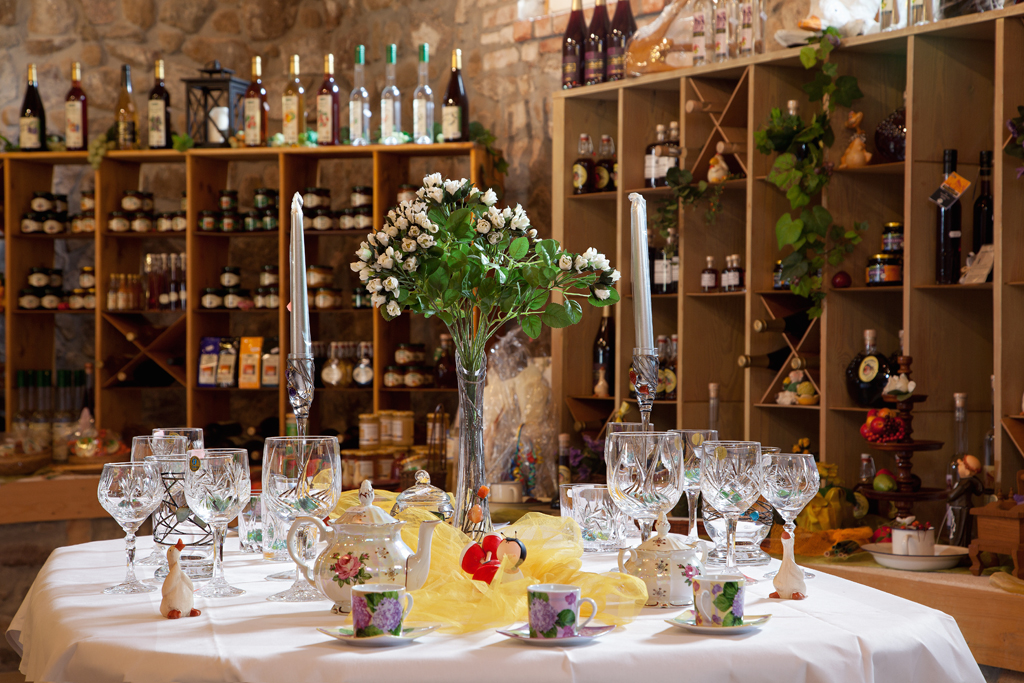 Festlich gedeckter Tisch mit Blumen, Gläsern und regionalen Produkten im Scheunenladen des Hotels Landhof Liepe